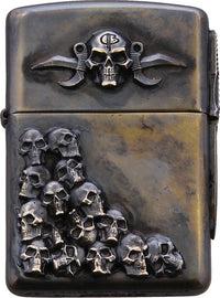 A bronze-colored metal Zippo lighter with a double-sided skull relief artwork.