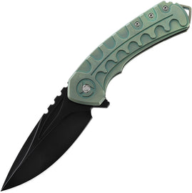 A folding knife with a green titanium handle and a black stonewash finish blade, featuring an extended tang, lanyard hole, and pocket clip. The knife is closed and displayed against a white background.