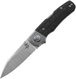 A folded hunting knife with a satin finish blade and black marbled carbon fiber handle, featuring a lockback mechanism and a titanium bolster.