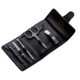 A manicure set including scissors, clippers, tweezers, a file, and a cuticle pusher, displayed on a black premium cowhide leather case.