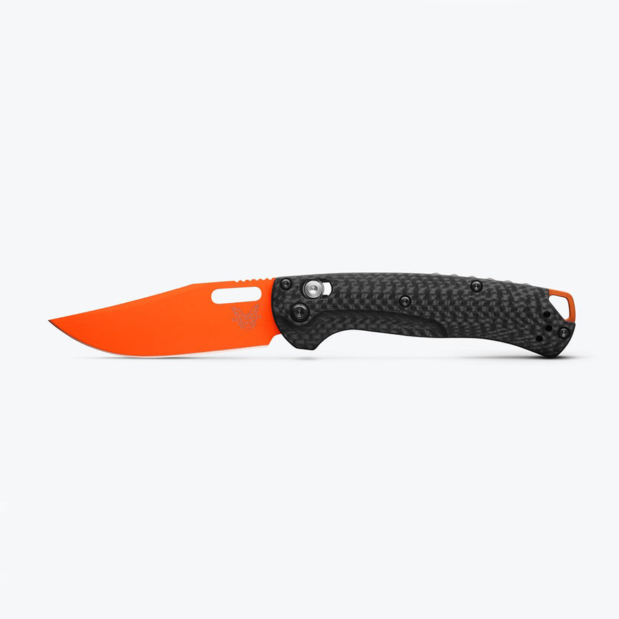 A folding knife with an orange handle and a black textured blade, featuring a clip point style and an axis lock mechanism.