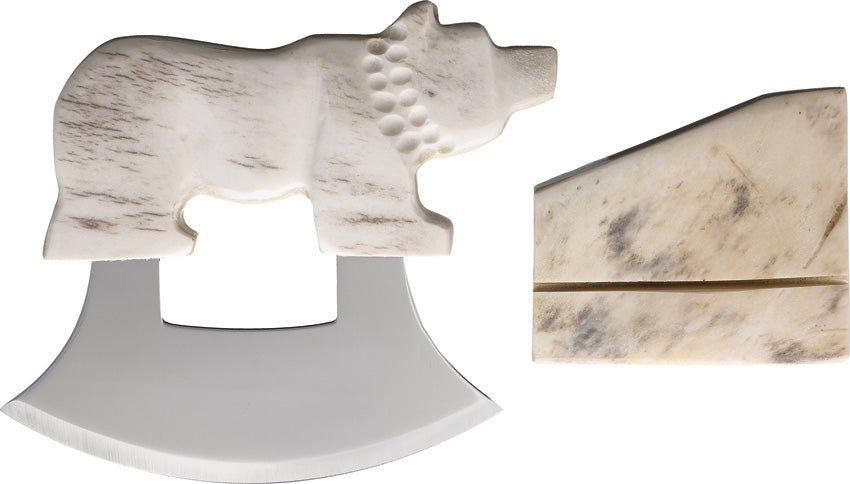 A knife with a mirror finish stainless blade and a sun bleached moose antler handle shaped like a bear, alongside a matching stand.