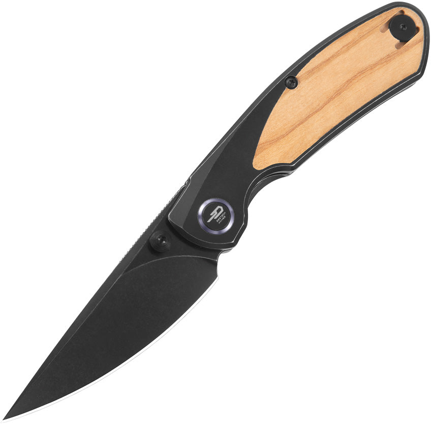 A foldable hunting knife with a black stonewash finish blade and a black titanium handle with olive wood inlay, including a thumb stud and pocket clip, closed position.