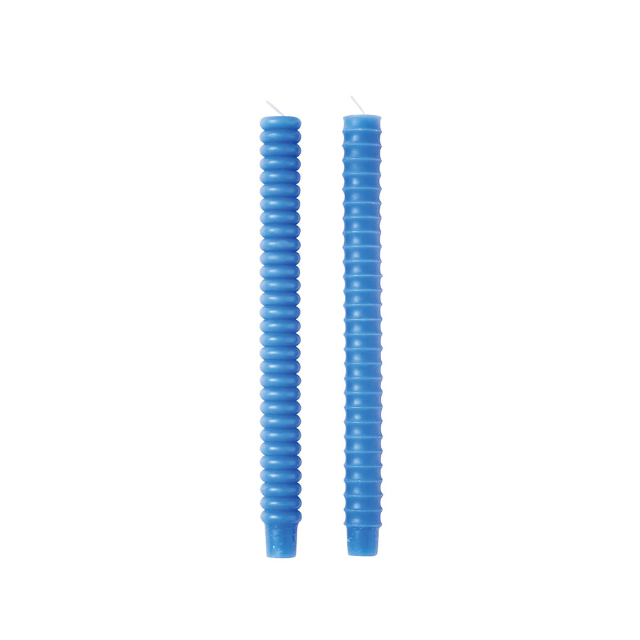 Two blue taper candles with a smooth finish and distinctive, curved design, displayed against a white background.