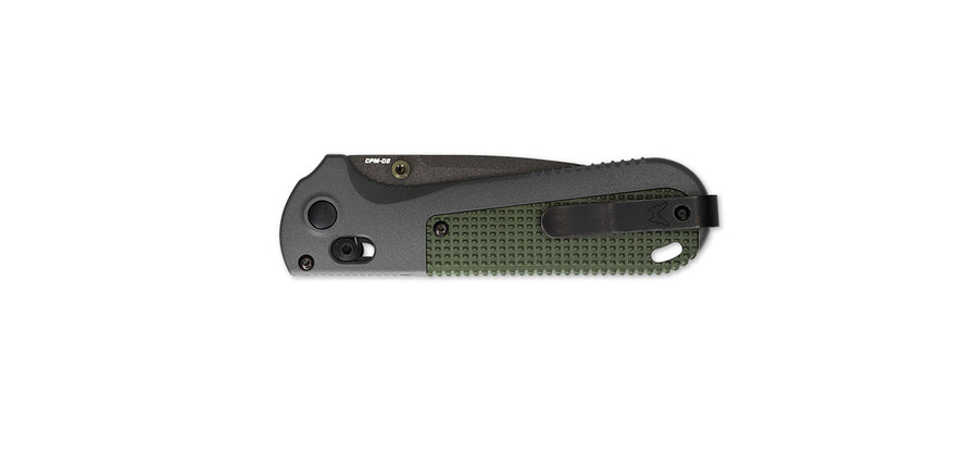 A Benchmade folding knife with a serrated edge and a green handle.